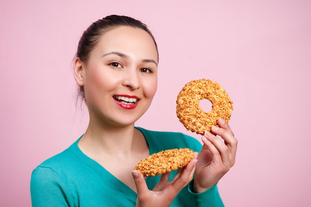 Uma jovem sorridente com doces nas mãos dela.