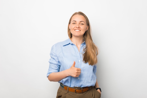 Uma jovem sorridente está olhando para a câmera com um polegar para cima