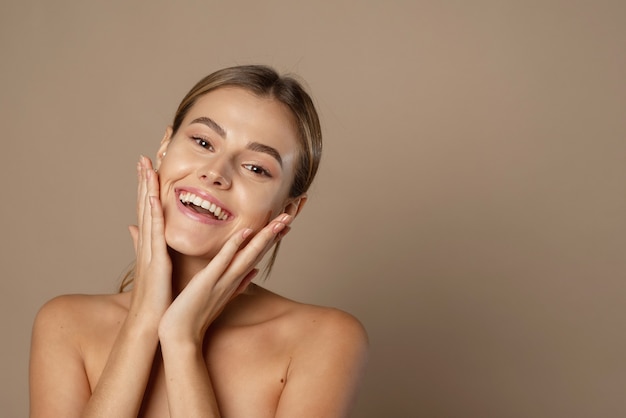 Uma jovem sorridente feliz com uma pele perfeita, maquiagem natural e um lindo sorriso.