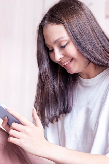 Uma jovem sorridente sorrindo em seu telefone passando tempo nas redes sociais