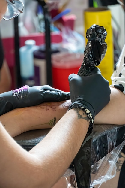 Uma jovem tatuadora profissional fazendo tatuagens em um evento público mulher latina