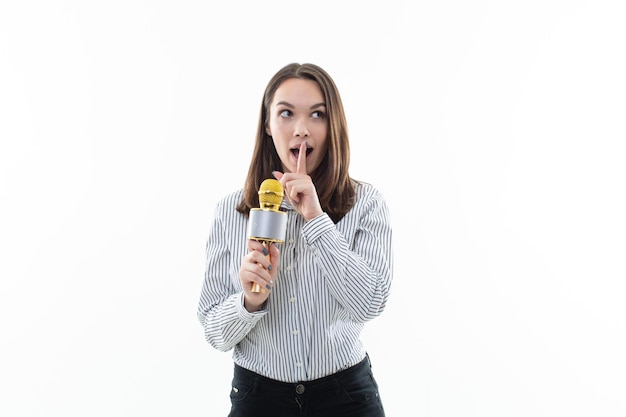 Uma jovem teve a ideia do que cantar no karaokê Retrato de uma bela jovem com um microfone nas mãos em um fundo branco Karaoke club