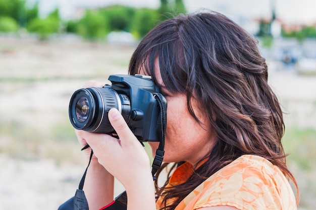 Foto uma jovem tirando foto com uma câmera reflex