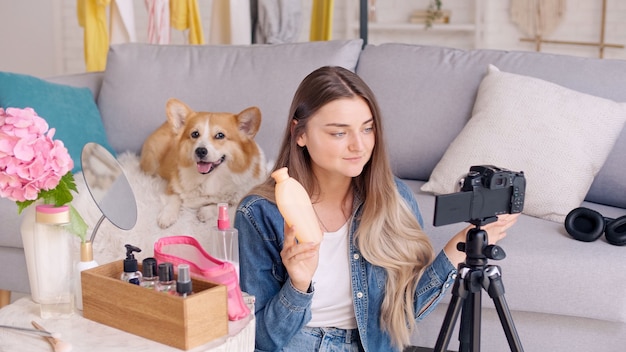 Uma jovem, uma blogueira de beleza, filma seu vídeo-blog sobre beleza. revisão de cosmetics live at home. freelancer influente. próxima geração de influenciadores da beleza