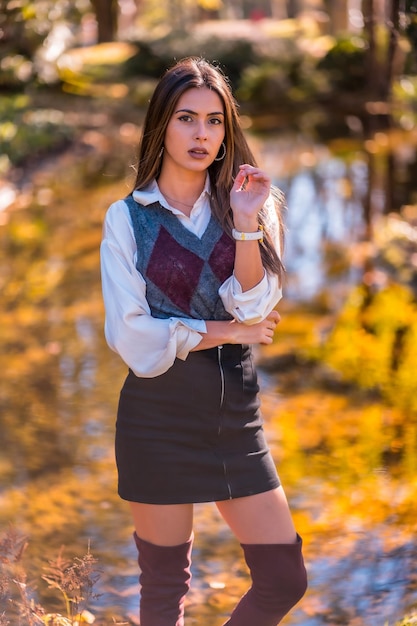 Uma jovem universitária morena caucasiana em um parque perto de um lago