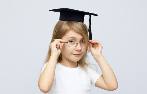 Uma jovem usa um boné preto de formatura com uma borla em branco