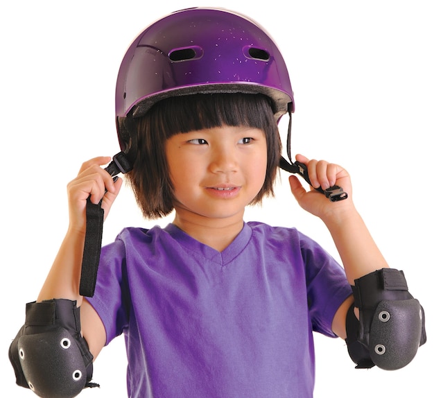 Uma jovem usando cotoveleiras protetoras coloca seu capacete pronto para andar de bicicleta