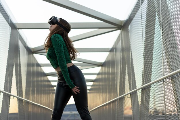 Uma jovem usando óculos de realidade virtual em uma ponte pedonal