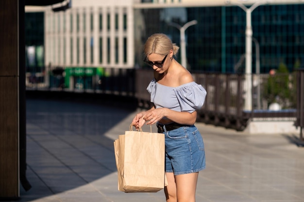 Uma jovem vai às compras com sacos de papel