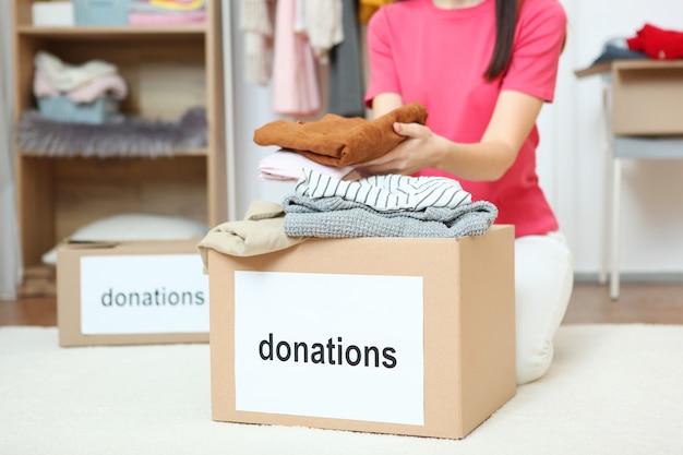 Uma jovem voluntária coleta uma caixa de doações para quem precisa