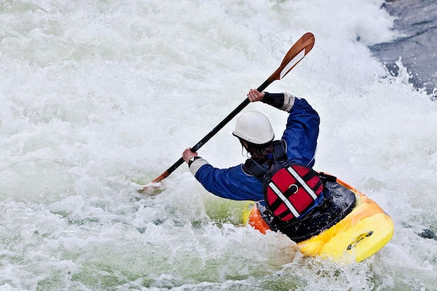 Foto uma kayaker ativa rolando e surfando em águas agitadas