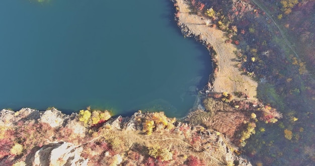 Uma lagoa de pedreira formada durante a mineração de pedra coberta de plantas verdes com águas cristalinas azul-turquesa