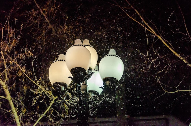 Foto uma lâmpada de rua com luzes brancas e um céu escuro atrás dela.