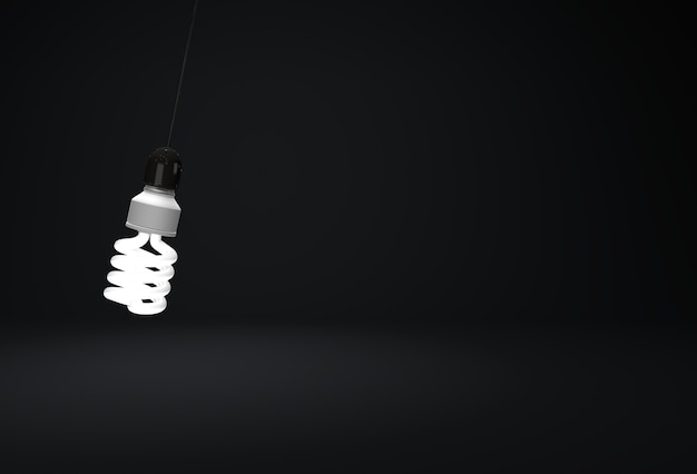 Uma lâmpada economizadora de energia pendurada em um fio na sala escura
