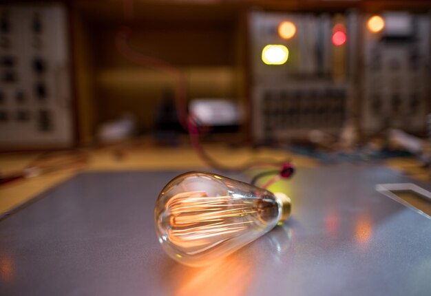 Uma lâmpada incandescente ilumina uma sala escura com luz laranja