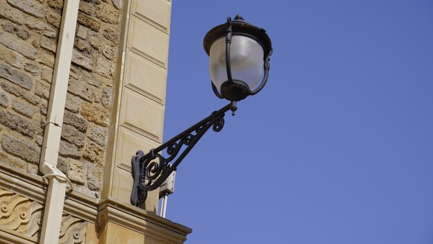 Uma lâmpada num edifício que diz o nome da rua.