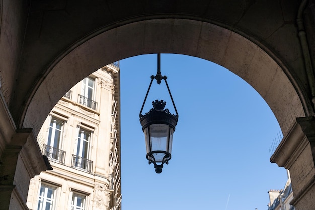 Uma lâmpada pendurada de um arco de um edifício