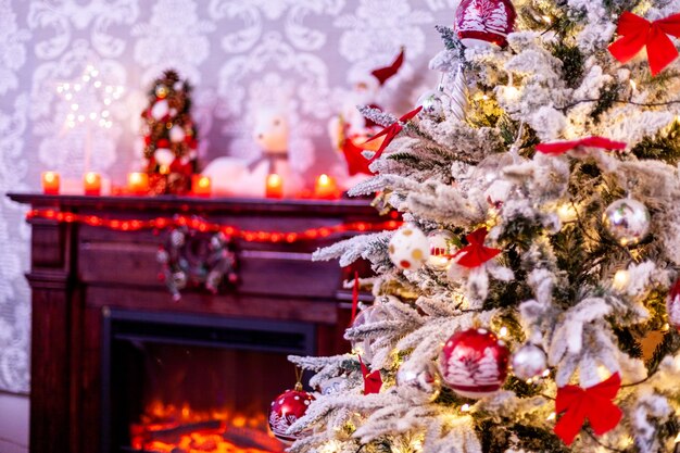 Uma lareira tradicional com muitas velas e árvore de natal. Decoração de Natal.