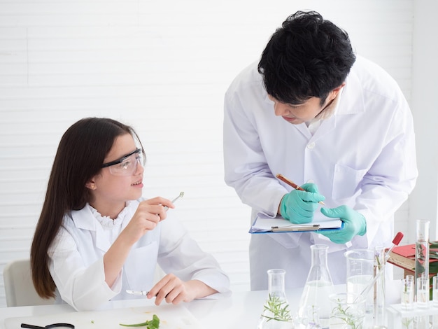 Uma linda aluna caucasiana está explicando os resultados de um experimento de aloe vera que ela descobriu no laboratório para seu professor durante a aula