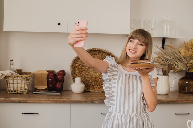 Uma linda confeiteira ou dona de casa faz uma selfie ao telefone Conceito de blog de culinária