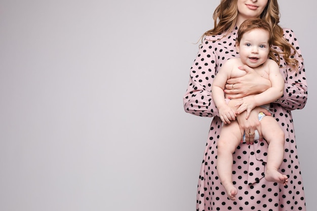 Uma linda família com uma criança pequena no estúdio em um fundo cinza