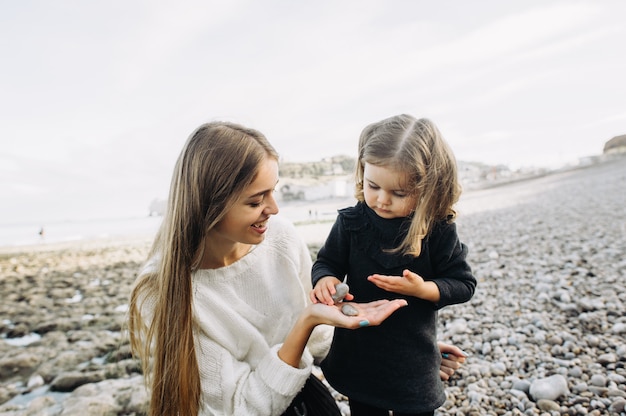 Uma linda família jovem na costa arenosa do oceano relaxando e se divertindo