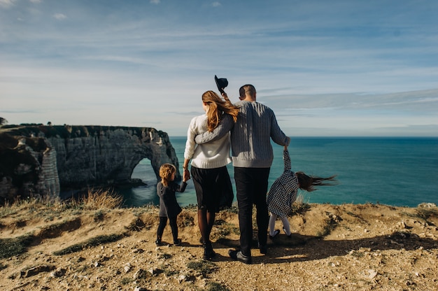 Uma linda família jovem na costa arenosa do oceano relaxando e se divertindo