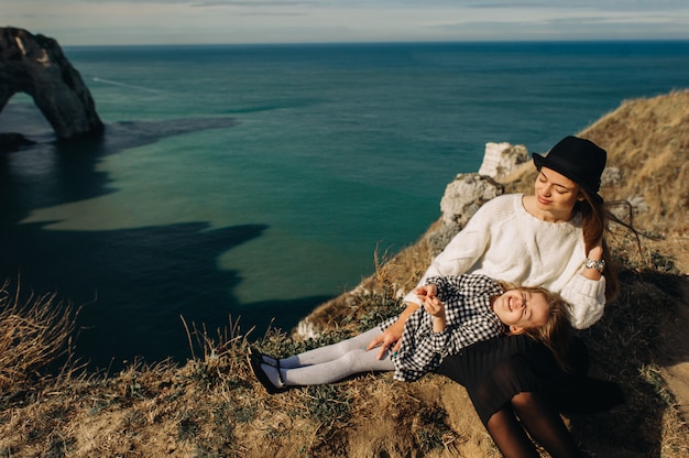 Uma linda família jovem na costa arenosa do oceano relaxando e se divertindo