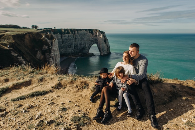 Uma linda família jovem na costa arenosa do oceano relaxando e se divertindo