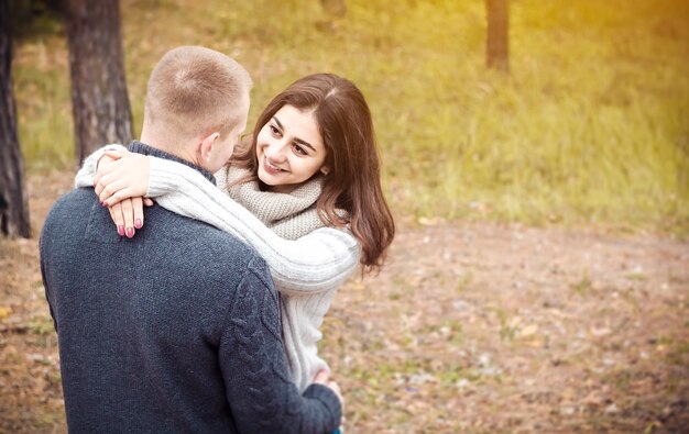 Foto uma linda garota abraça seu namorado. jovens felizes. o conceito de amor