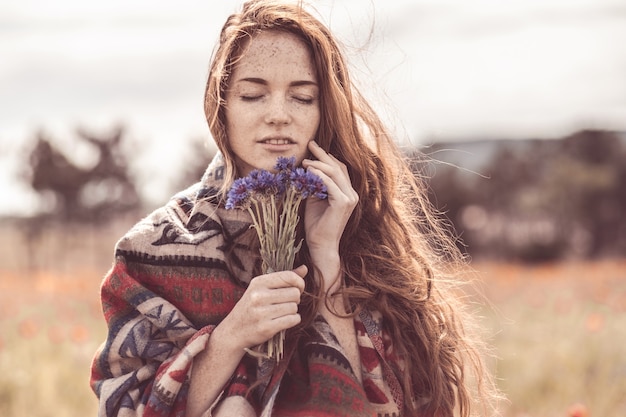 Uma linda garota aprecia o cheiro de um buquê de flores.