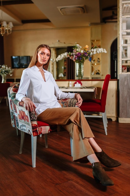 Foto uma linda garota mostrando roupas da moda contra o pano de fundo do cenário do restaurante roupas para o showroom