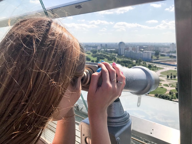 Foto uma linda garota olha para a paisagem um panorama da cidade na sala de observação um par