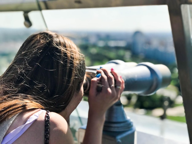 Foto uma linda garota olha para a paisagem um panorama da cidade na sala de observação um par