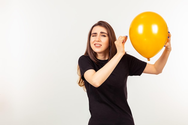 Uma linda garota segurando balão e piscando o olho