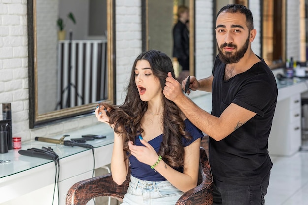 Uma linda garota segurando o cabelo com a mão e olhando com choque Foto de alta qualidade