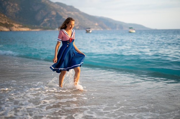 Uma linda garota sexy em um uniforme do mar caminha na praia