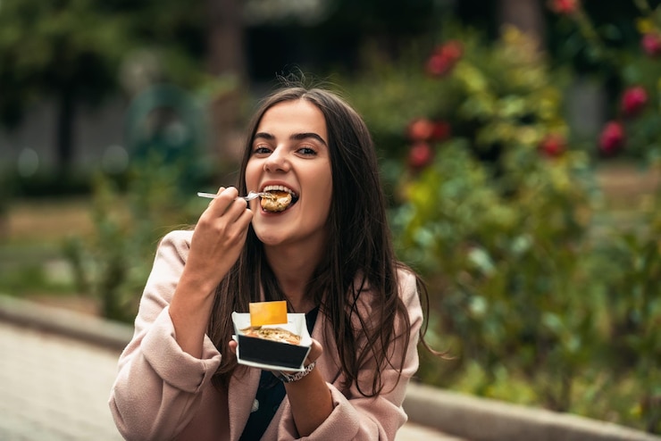 Foto uma linda garota sorridente come poffertjes frescos enquanto passeia pela cidade foco seletivo