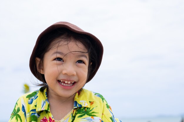 Uma linda garotinha feliz sorrindo na praia.