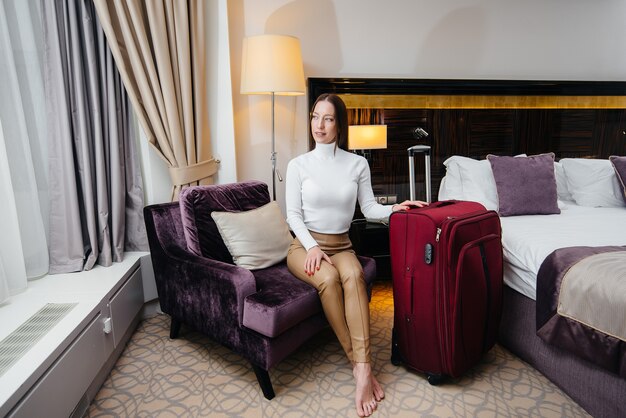 Uma linda jovem entrou em seu quarto em um hotel de luxo. Turismo e recreação.