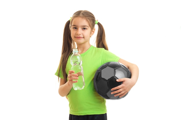 Uma linda menina bebe água depois de um jogo de futebol, isolado no fundo branco