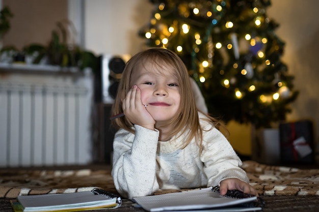 Uma linda menina escreve uma carta para o papai noel