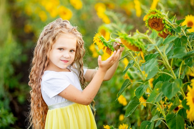 Uma linda menina segura um girassol em um campo no verão