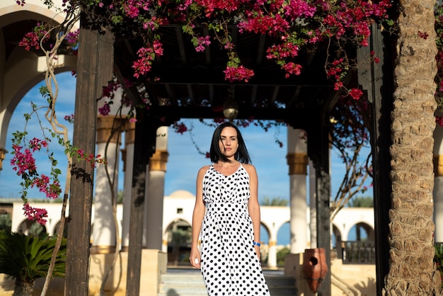 Uma linda mulher bronzeada no vestido preto de verão