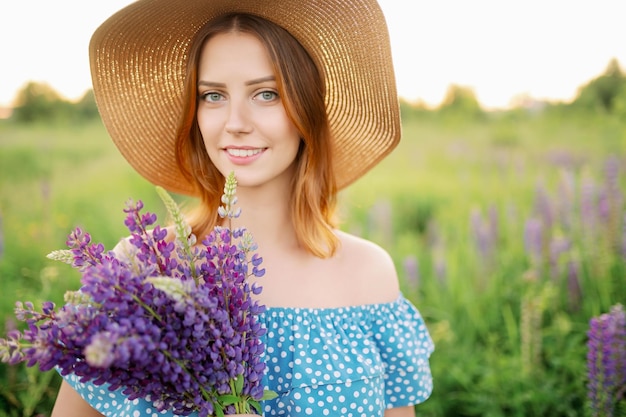 Uma linda mulher caucasiana de chapéu segura um buquê de tremoços e sorrisos