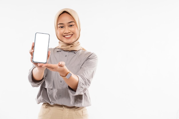 Uma linda mulher com hijab em pé mostrando o telefone