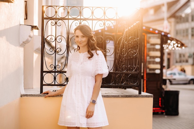 Uma linda mulher de vestido branco ao pôr do sol na cidade Fotografia de rua à noite