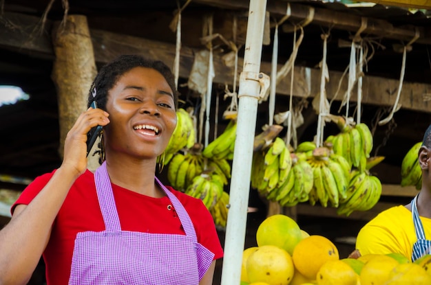 Uma linda mulher do mercado africano ficou animada com o que ela está fazendo em seu celular