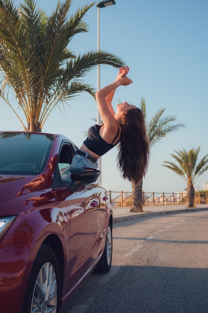 Uma linda mulher está posando para sair de um carro pela janela aberta