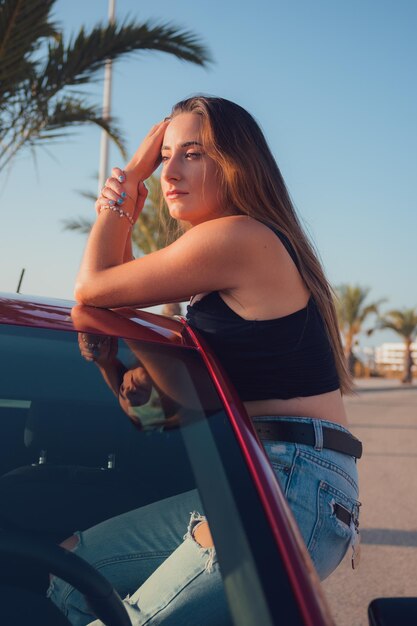 Uma linda mulher está posando para sair de um carro pela janela aberta